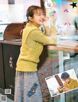 A woman sitting at a table with a cup of coffee.