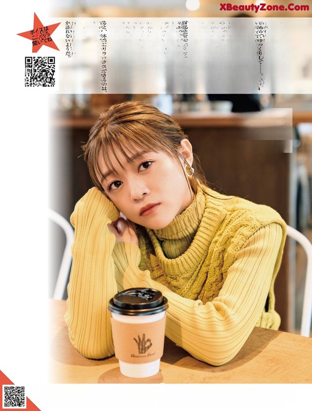 A woman sitting at a table with a cup of coffee.