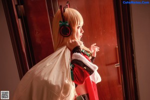 A woman dressed as a santa claus sitting on a window sill.