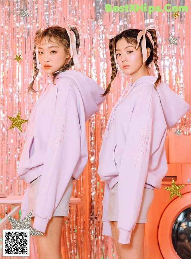 two girls standing next to each other in front of a washing machine
