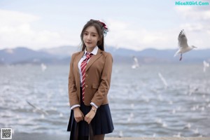 A woman in a school uniform sitting on a white chair.