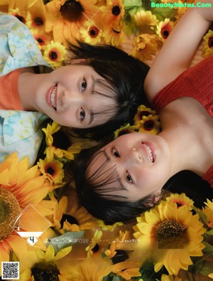 Two young women sitting next to each other on a window sill.