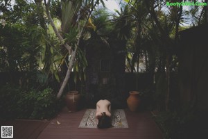 A naked woman standing on the edge of a swimming pool.