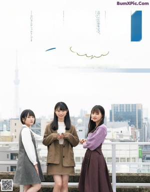 A woman in a school uniform standing in front of a city.