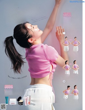 A woman in a pink shirt and white pants is doing yoga.