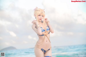 A woman in a bikini posing on the beach.