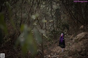 A woman with purple hair is posing for a picture.