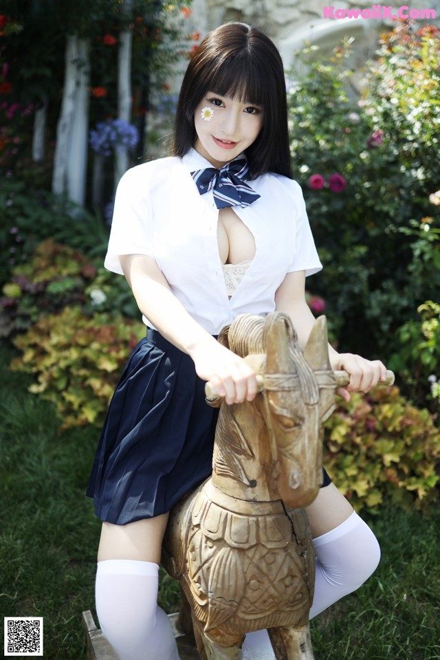 A woman in a school uniform riding a wooden horse.