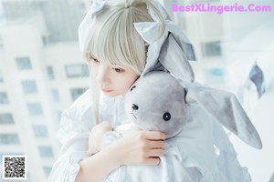 A woman sitting on a couch with a stuffed animal.