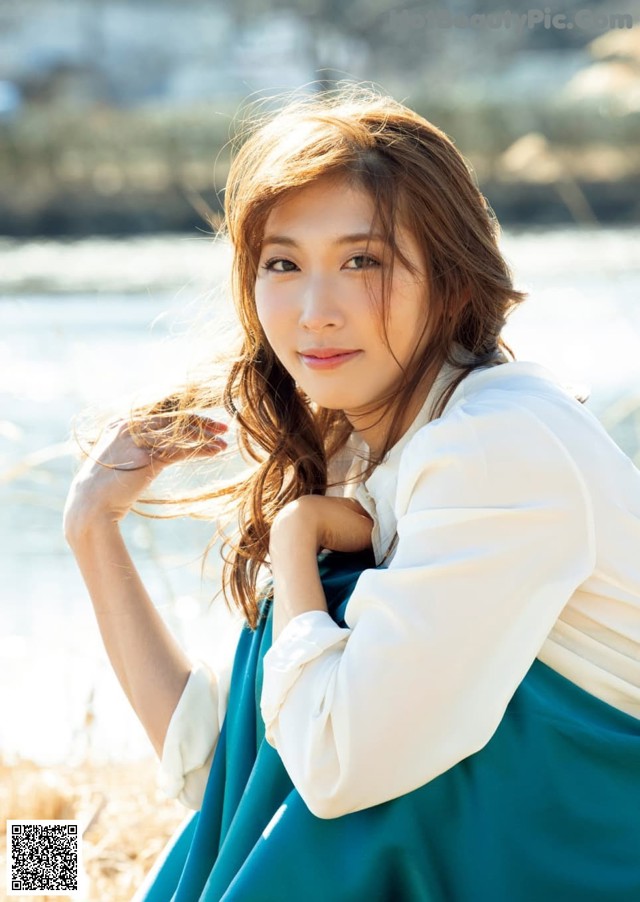 A woman in a blue and white dress posing for a picture.