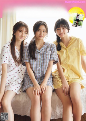 A group of young women sitting on top of a bed.