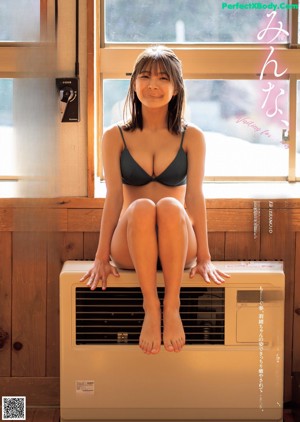 A woman in a black bikini sitting on a chair.