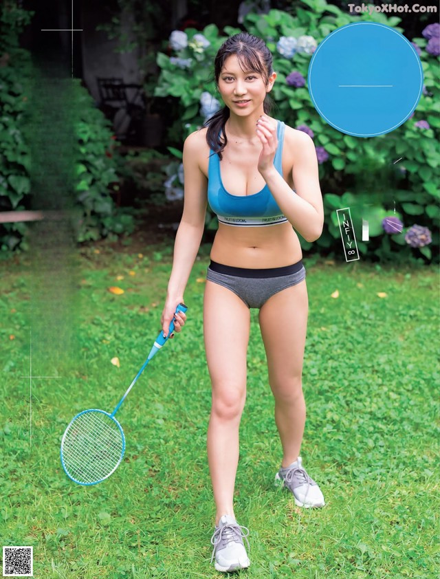 A woman in a bikini holding a badminton racket.