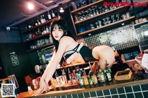 A woman in lingerie drinking from a glass.