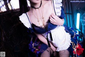 A woman dressed in a maid outfit posing for a picture.