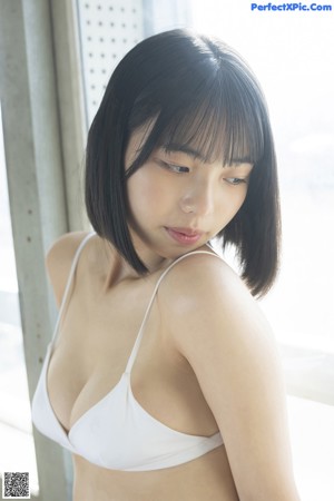 A woman in a white shirt and black skirt posing for a picture.